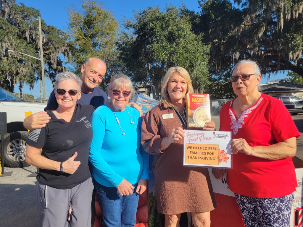 photo of 5 people outdoors holding non perishable food