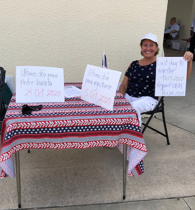 woman with white cap at voter registration table