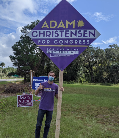 adam christensen with congressional sign outdoors