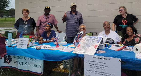 eight volunteers at table at voter registration